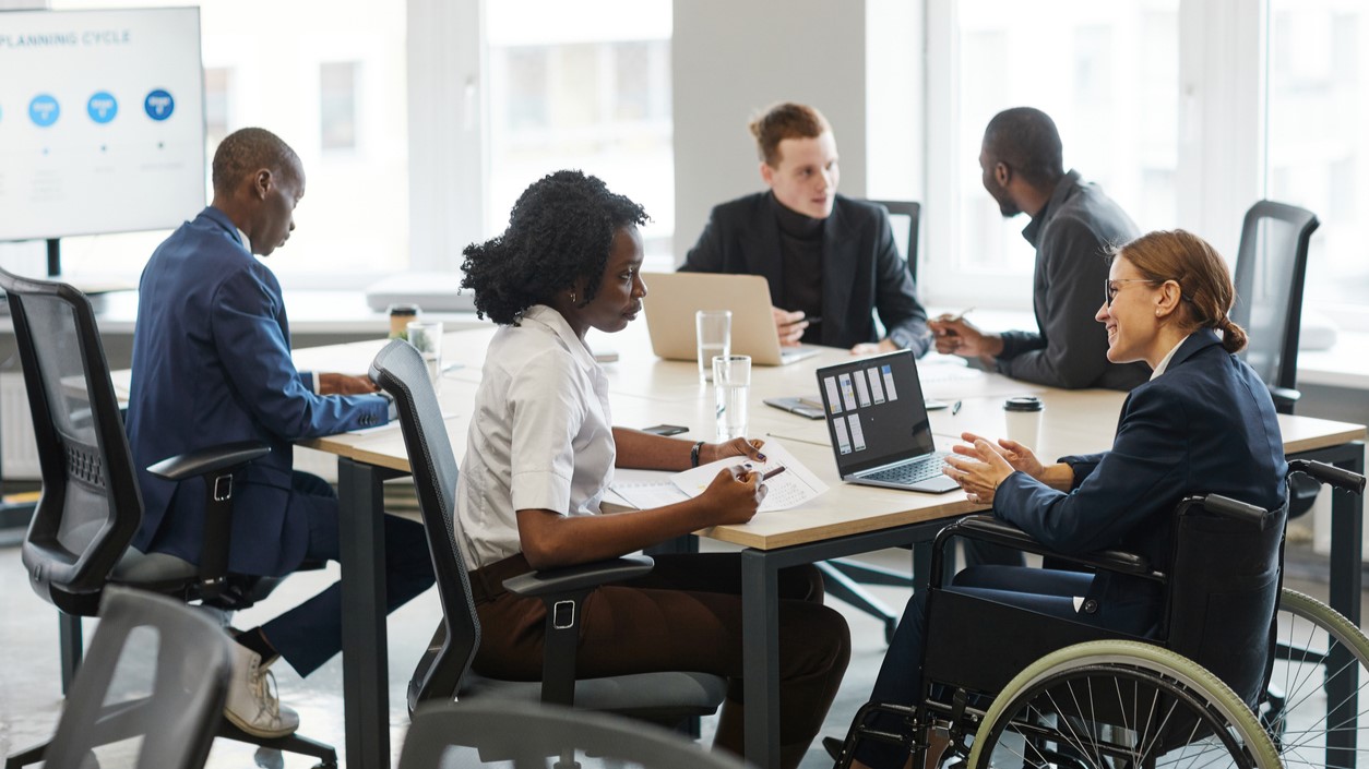 people in wheel chairs around a table working